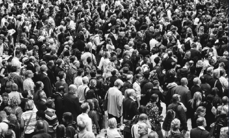 A black and white birds eye view photo of a crowd of over a hundred people.