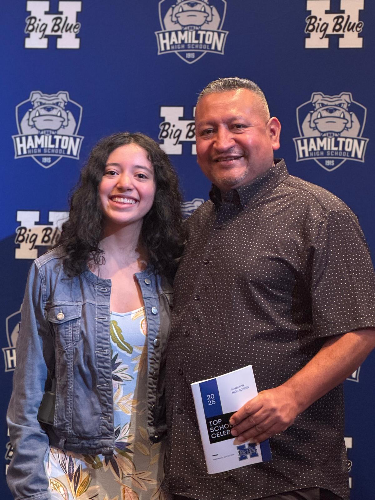 Me and my dad in front of a Hamilton High School background at the top scholar ceremony.